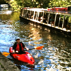 Busy waterway beside the Regent's Canal, with canoeing and barges 