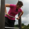 A woman learning how to exercise, working out on a climbing frame