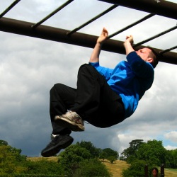A fitness trainer demonstrates his own weight loss success, using monkey bars